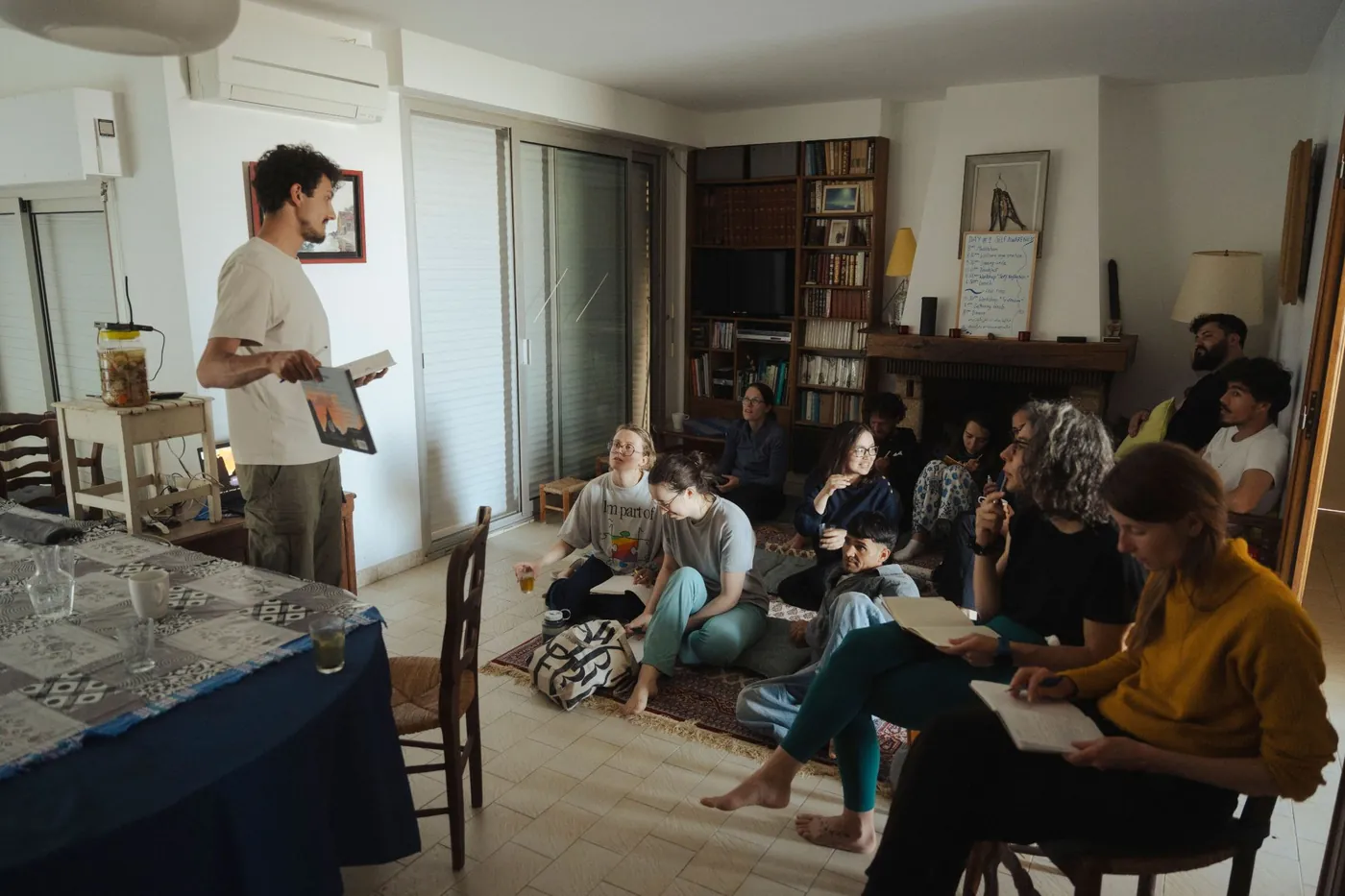 Julien Porte presenting his book to the retreat participants, sitting on the living-room floor